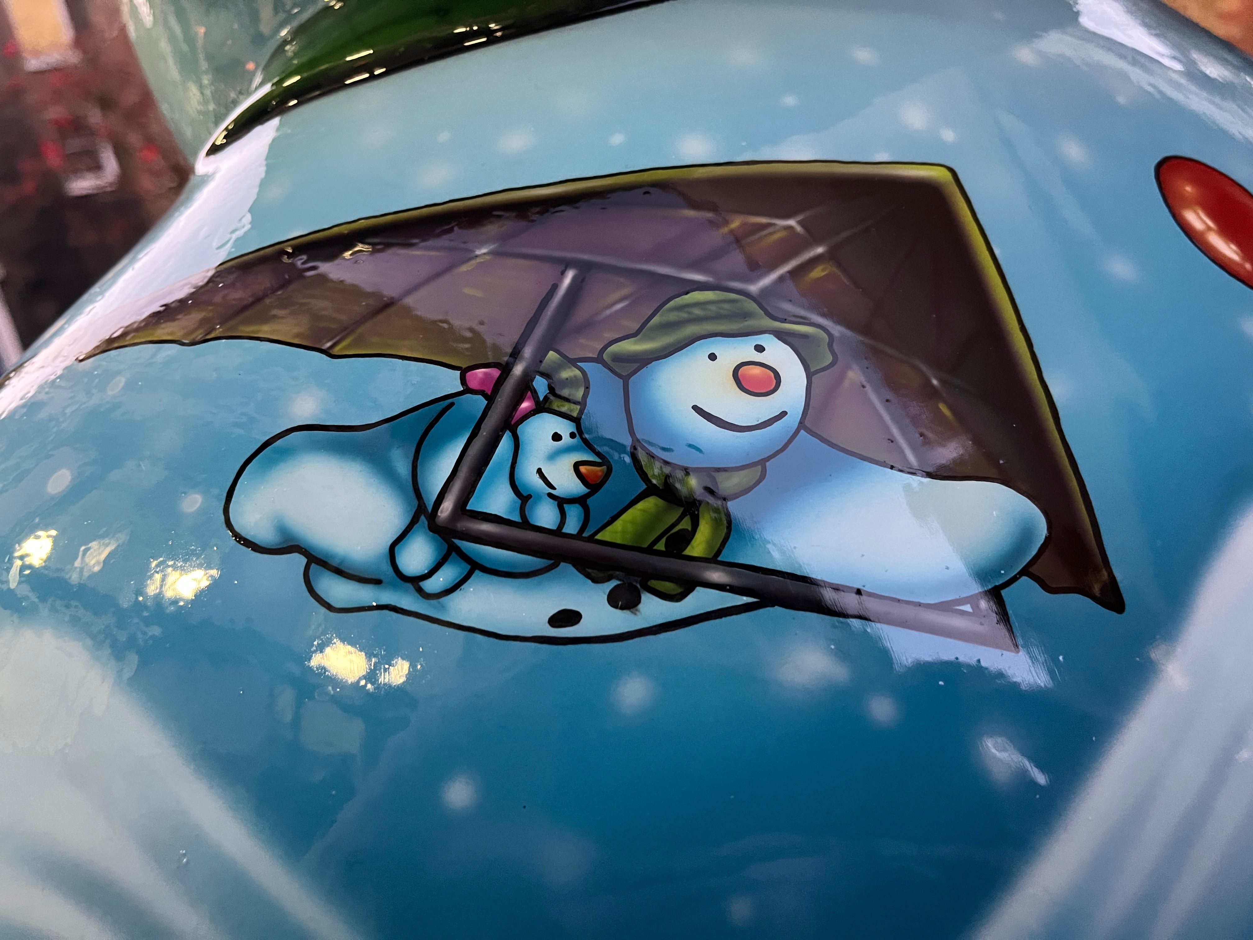 Close-up of the Ten Lords a-Leaping sculpture of the Snowman, showing the character hang-gliding, and carrying the Snowdog under one harm.