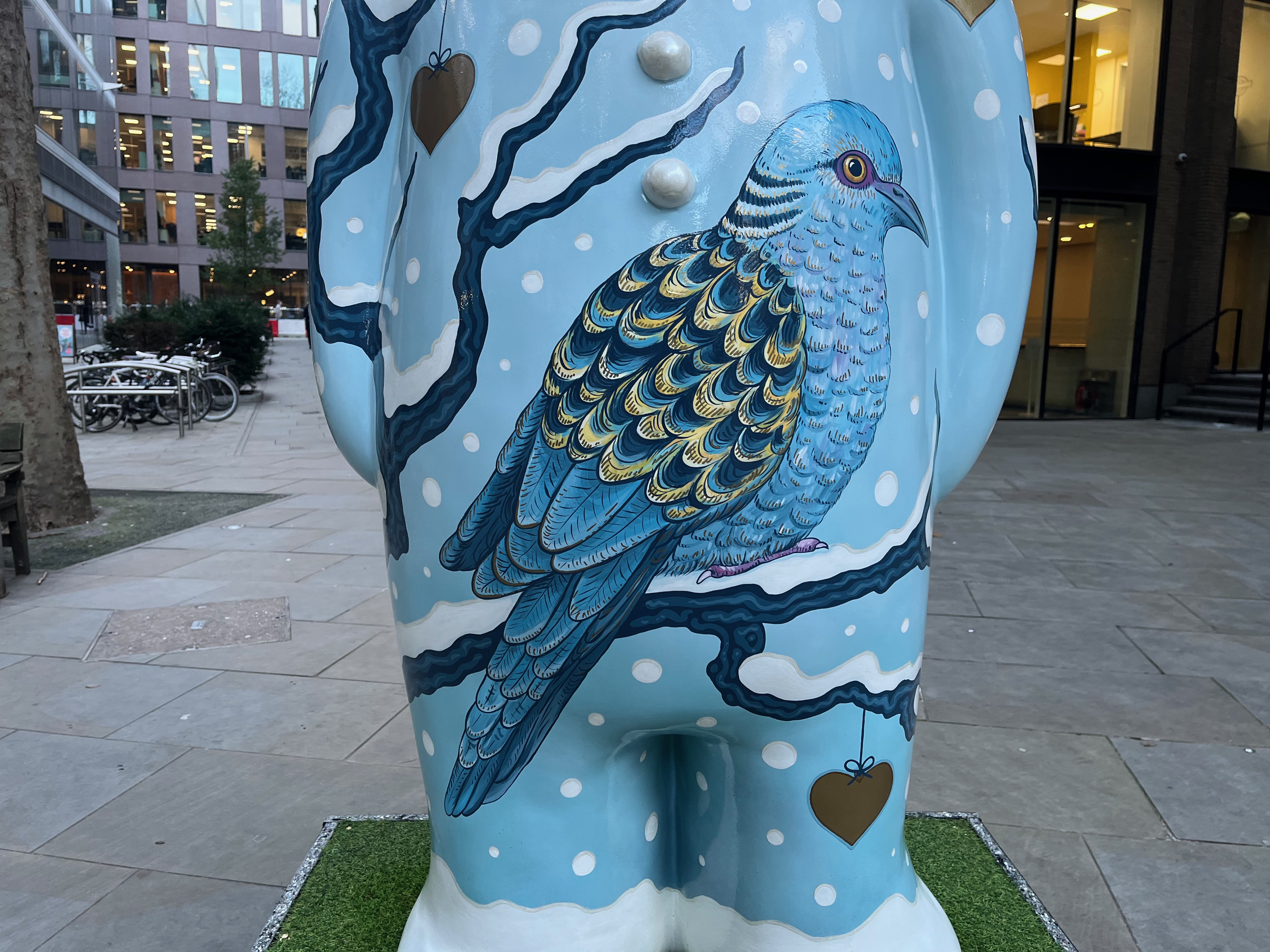 Close-up of a blue turtle dove on the front of The Snowman sculpture called Two Turtle Doves. It has lots of detail to its feathers, including some darker colours making up the back of its wings.