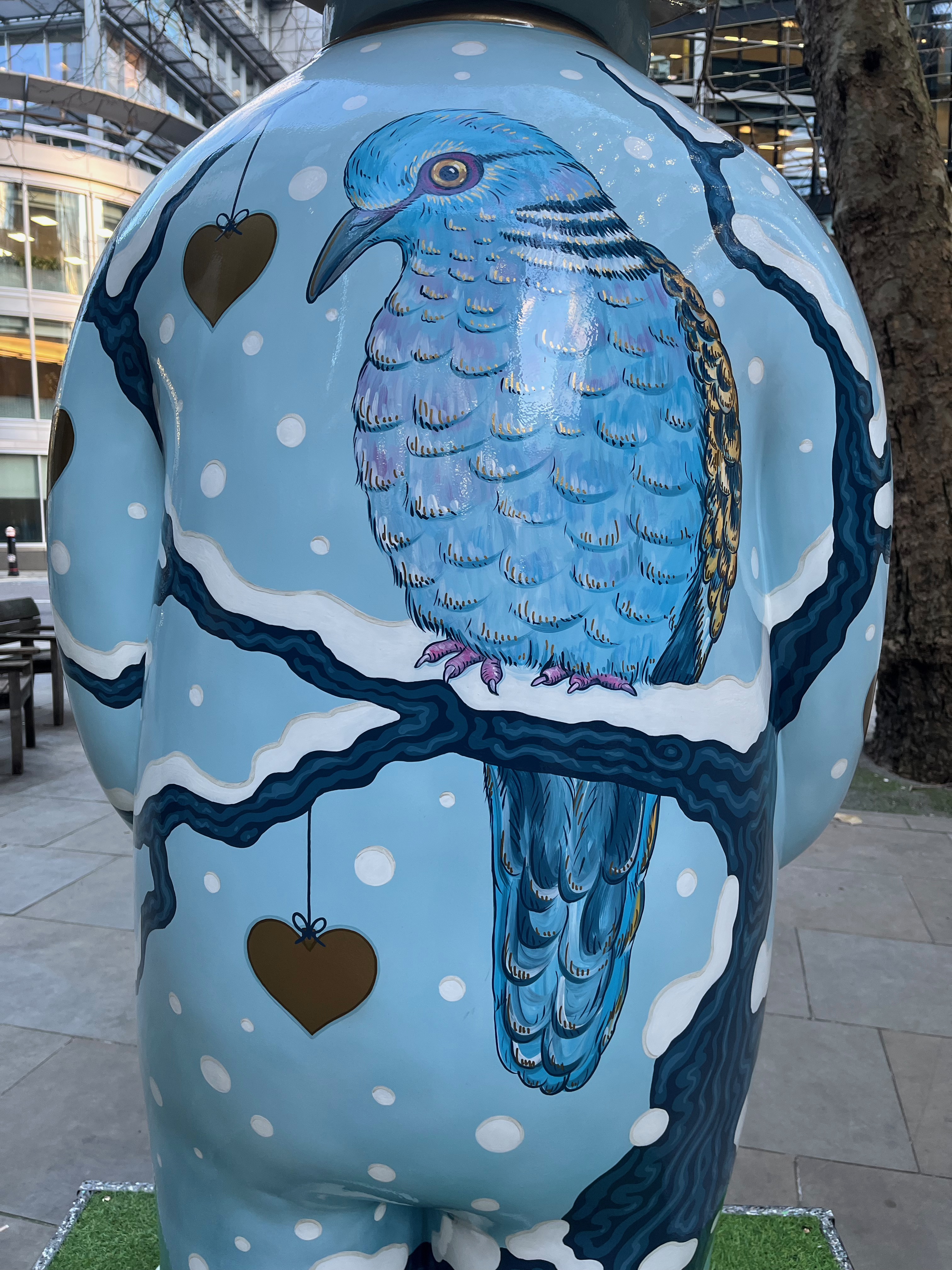 Close-up of a blue turtle dove on the back of The Snowman sculpture called Two Turtle Doves. It is facing us, with its blue chest covered in lots of feathers, and there is just a glimpse of the darker feathers on its back.