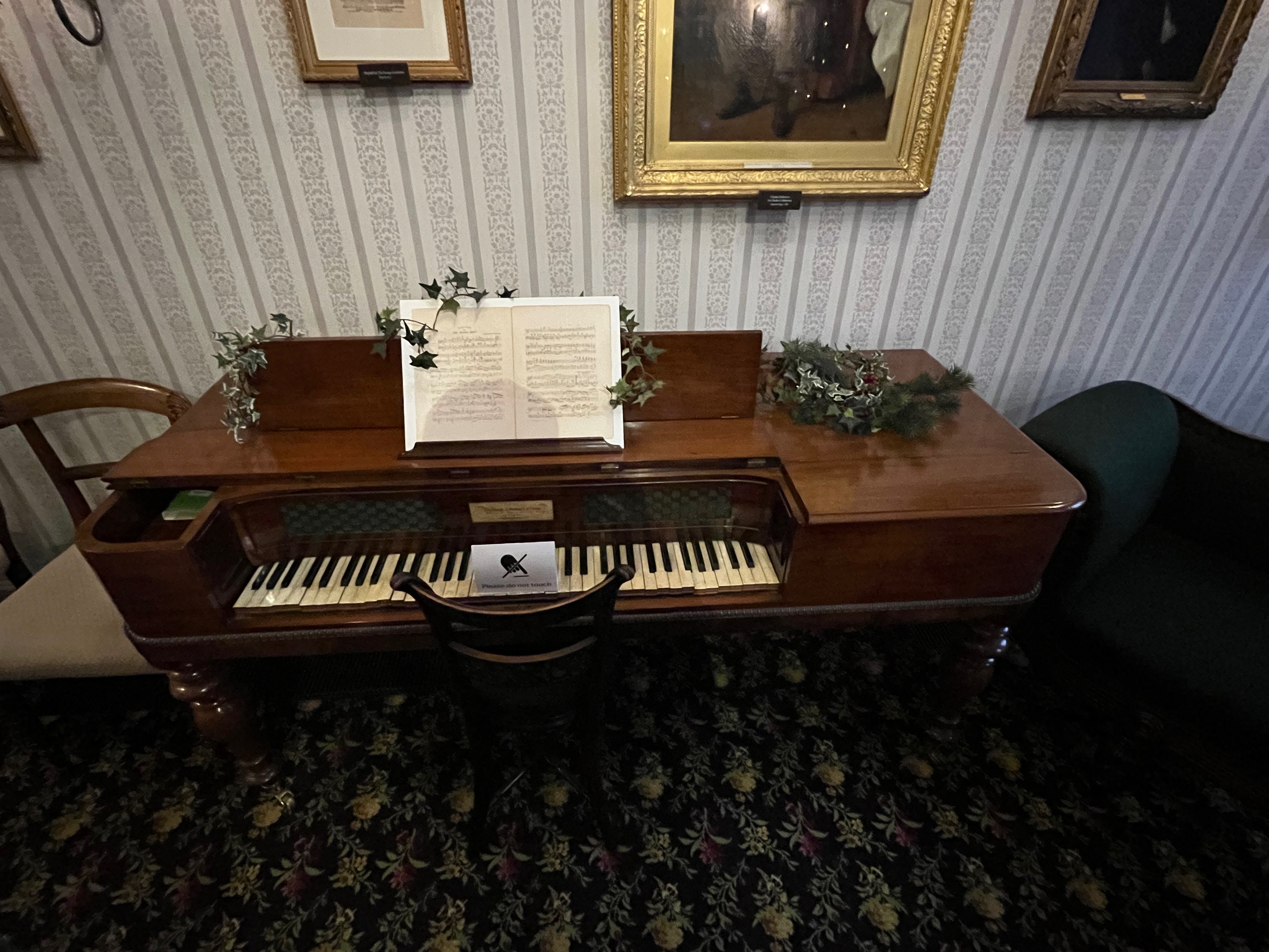 A piano in the Charles Dickens Museum with some sheet music on the stand.