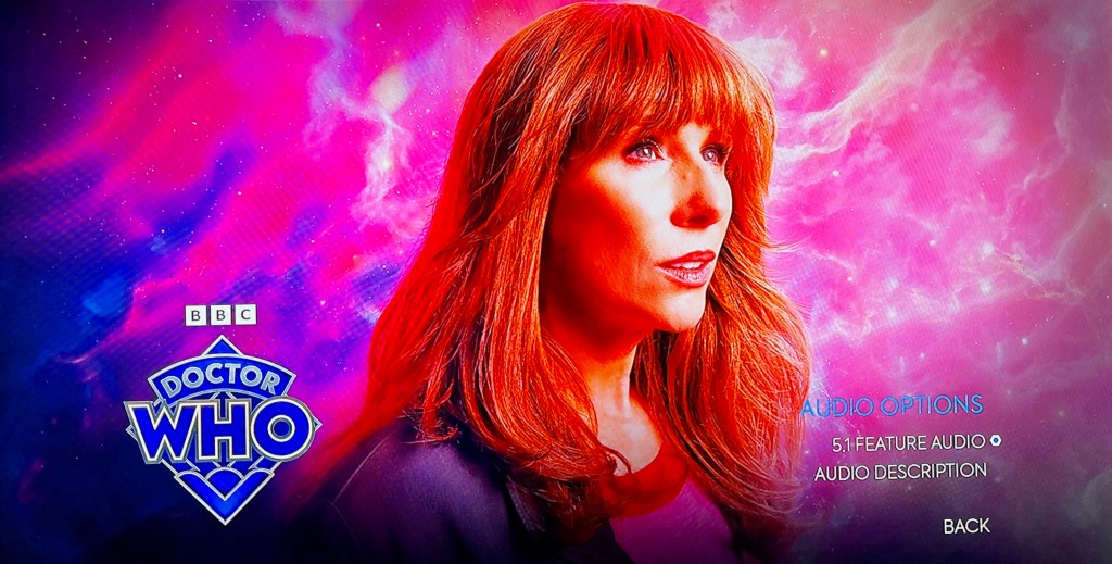 Audio Options menu on the Blu-ray for the Doctor Who 60th Anniversary Specials, showing a close-up of redhead Donna Noble. In the bottom right corner are options for 5.1 feature audio or audio description. The Doctor Who logo is in the bottom left corner.