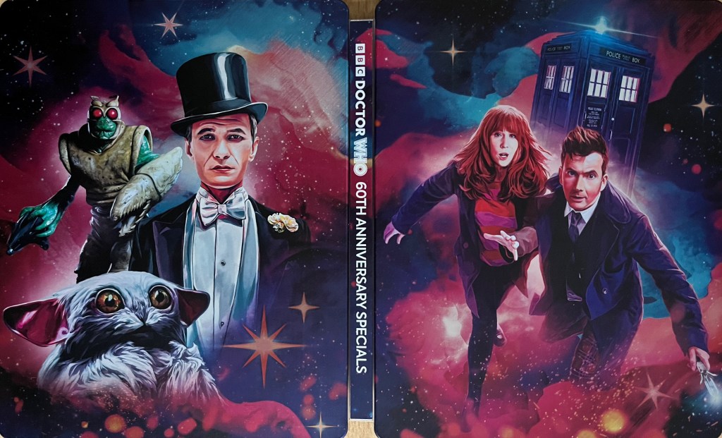 The full cover spread artwork for the Doctor Who 60th Anniversary Specials Blu-ray steelbook. The front cover shows David Tennant's Doctor and Donna Noble running urgently towards us, with the Tardis flying the background, while the back cover shows a green alien Wrarth Warrior, the small white furry Meep and the smartly suited Toymaker. All of this imagery is set against a background of the universe with stars and galaxies.