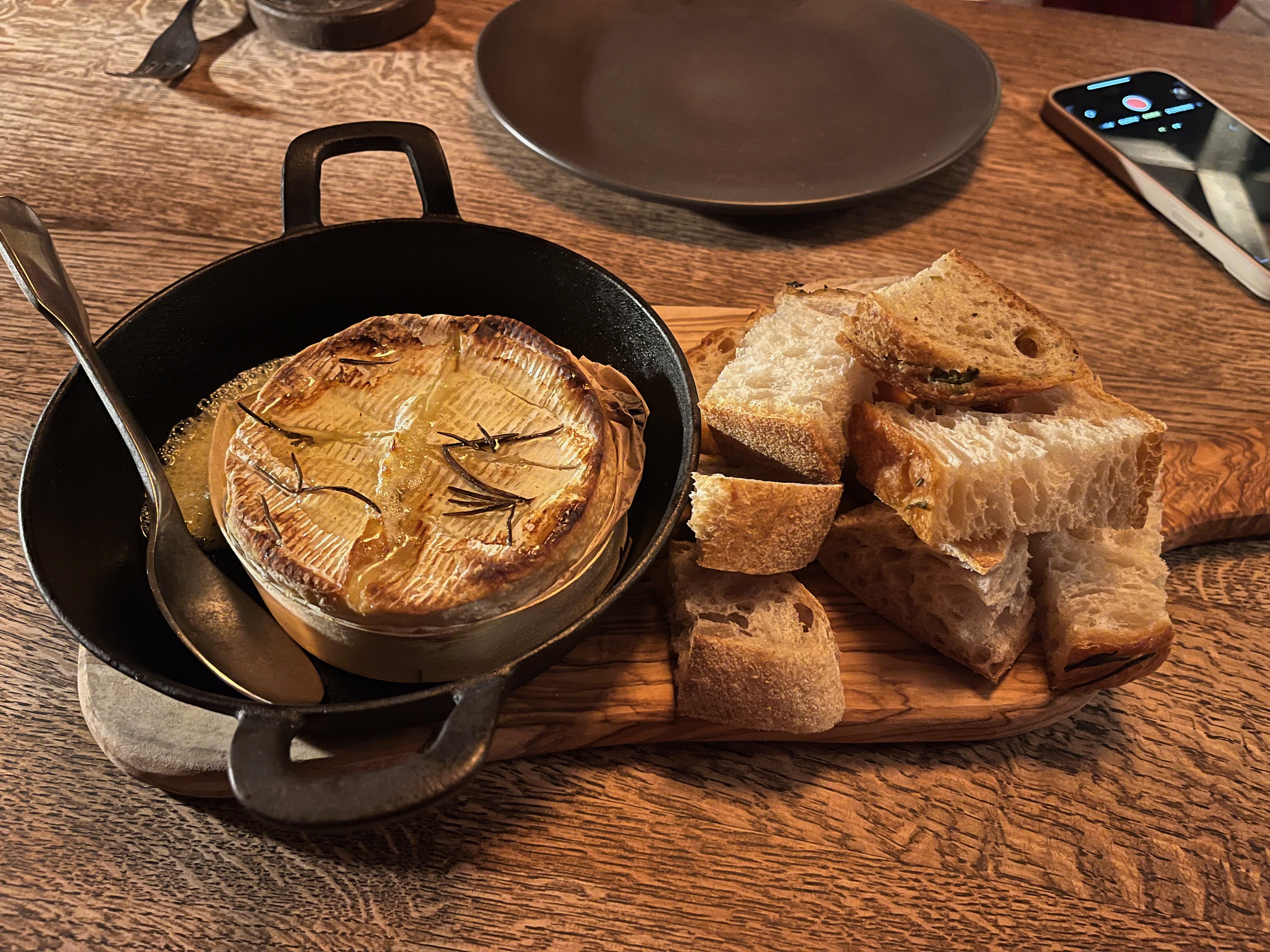 A dish of Baked Tunworth cheese, with some torn up pieces of bread beside it, at the In Horto restaurant.