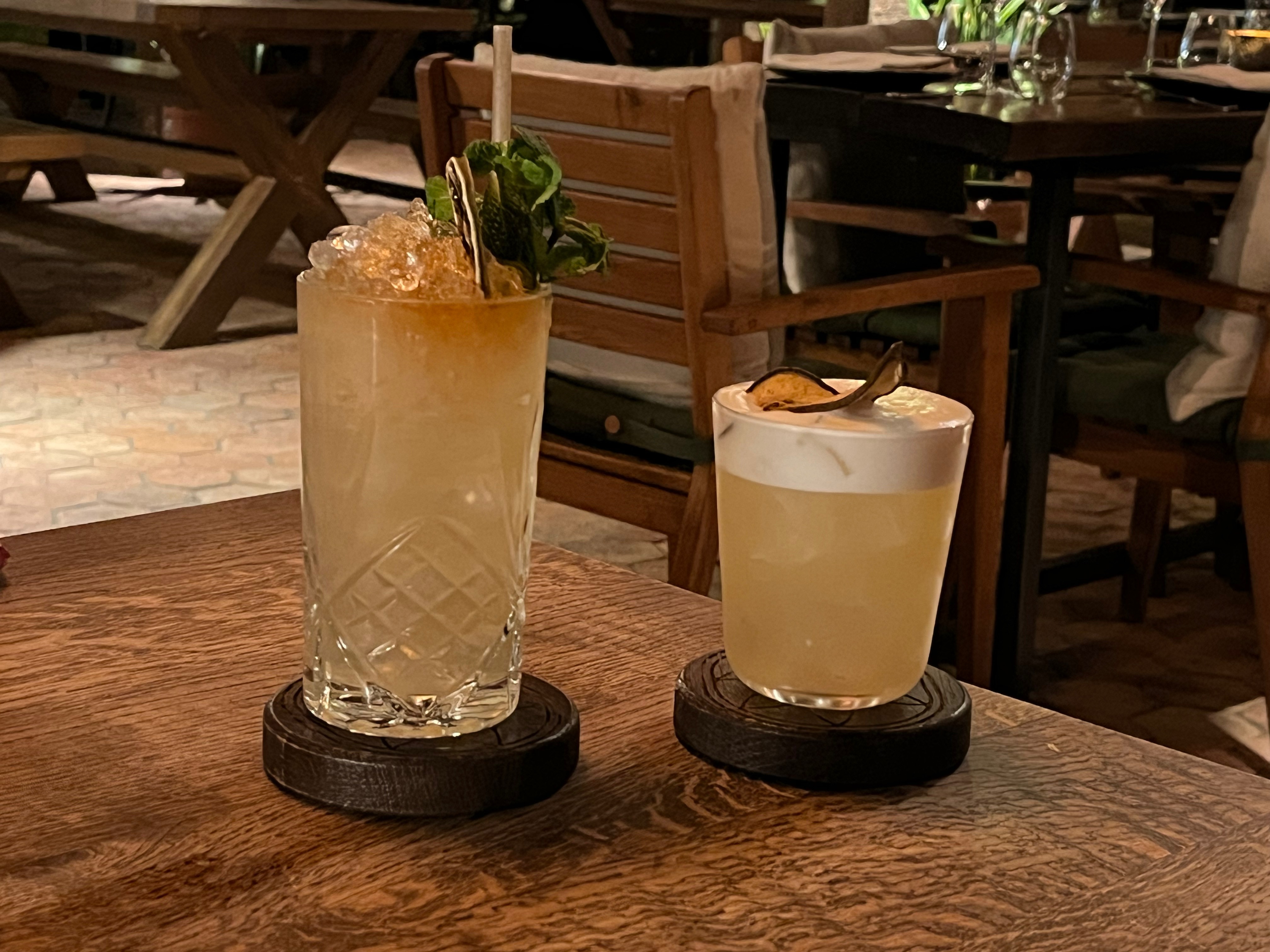 Glasses containing a winter mule cocktail and a pear sour cocktail at the In Horto restaurant.