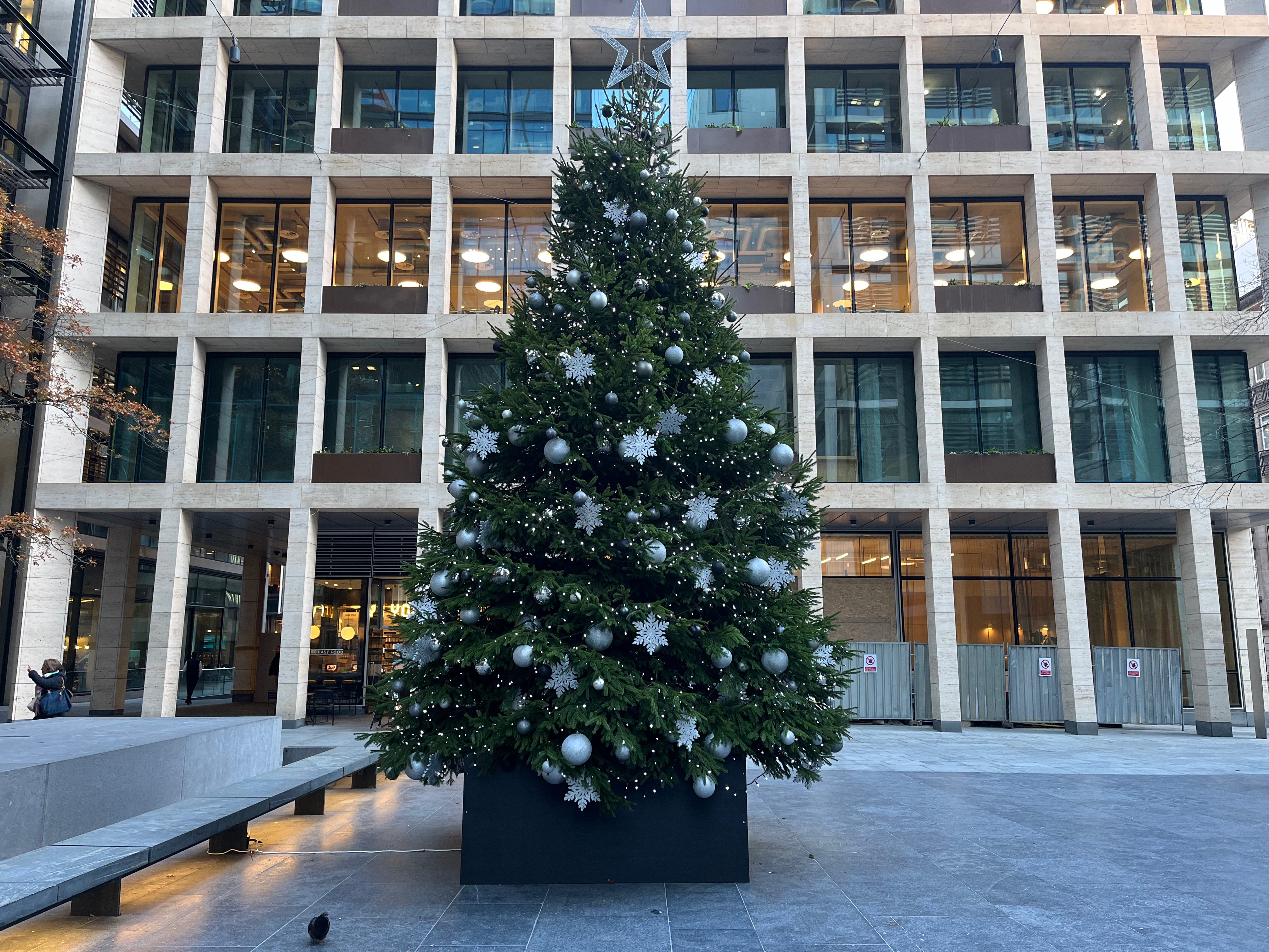 Large Christmas tree in New Street Square, decorated with lots of white snowflakes, silver baubles, and hundreds of little lights.