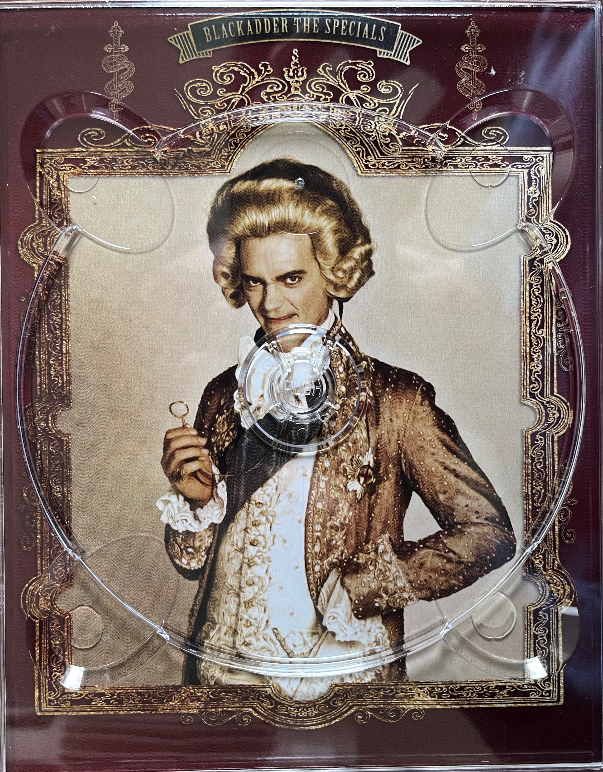 Artwork behind the disc holder for the Specials in the Blackadder Complete Collection Blu-ray box set, featuring a large image of George, the Prince Regent, surrounded by an ornate gold frame.