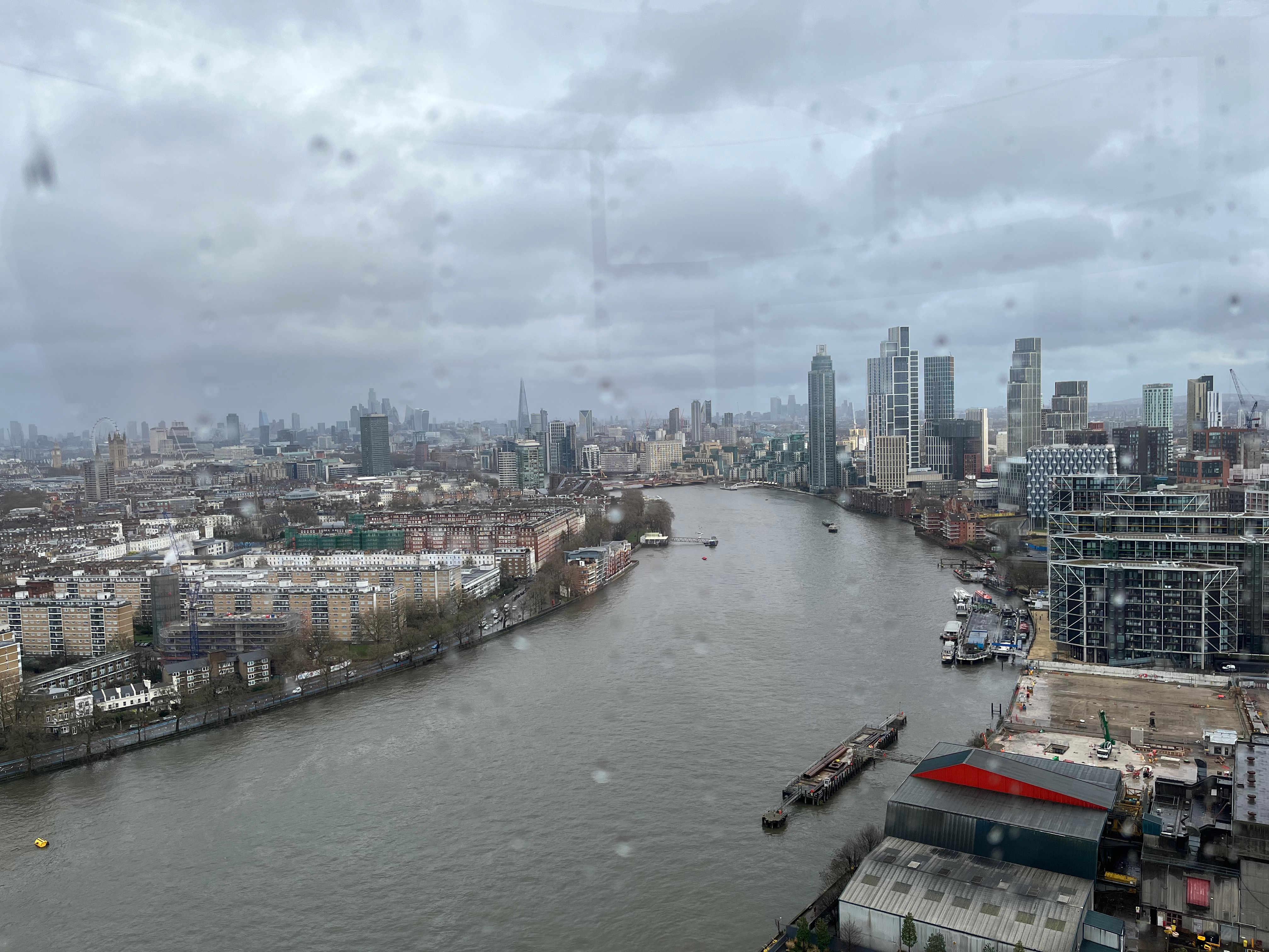 A high view over the Thames from Lift 109 in Battersea Power Station, as it curves away to the left in the distance. Just beyond the next bridge in the distance is the MI6 Building. And further left it's possible to see the Shard, London Eye and Big Ben in the far distance.