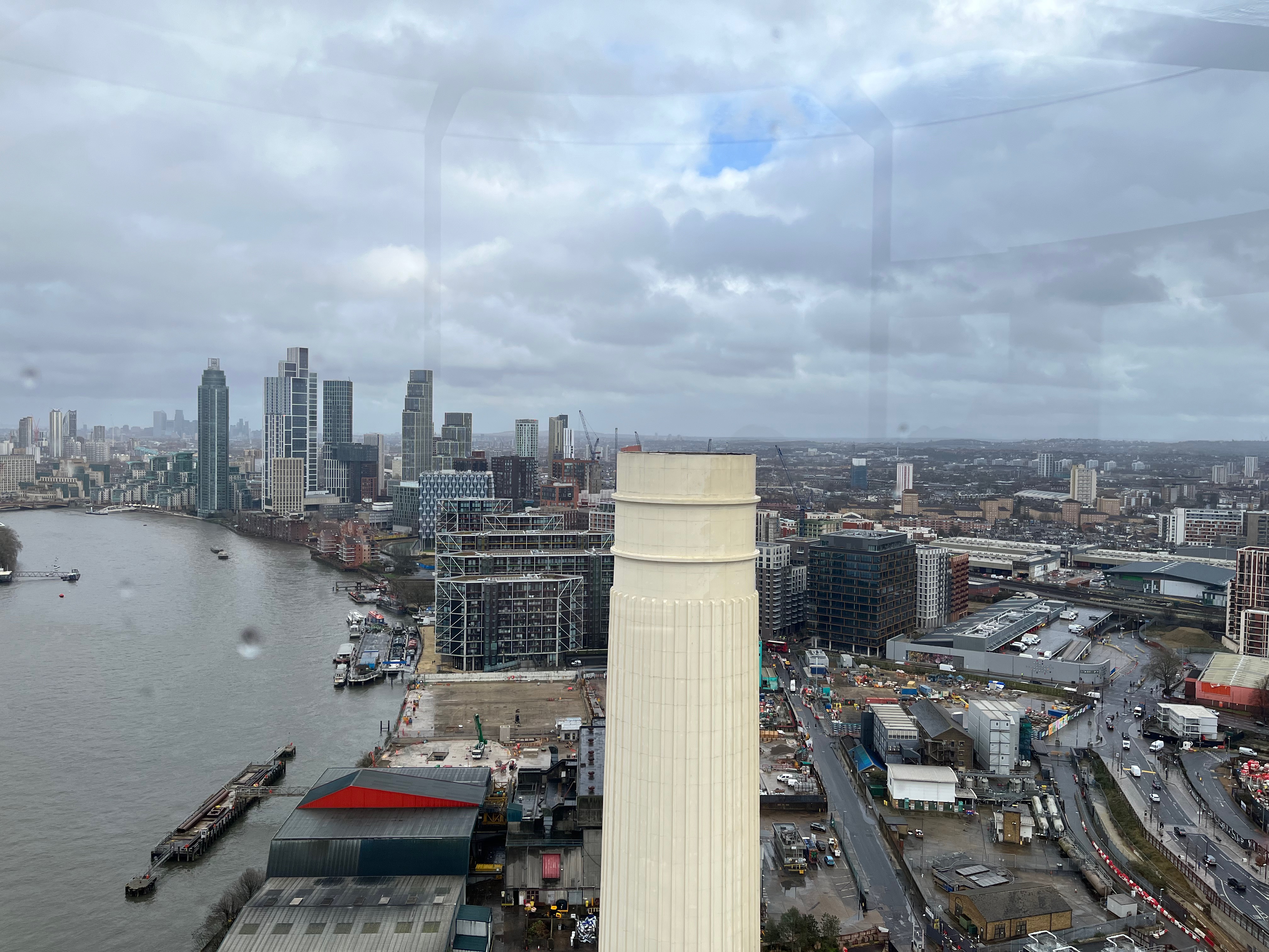 A high view over London on the south side of the Thames from Lift 109 in Battersea Power Station. The view faces the other chimney on the front of the building, which sits in the centre of the picture.