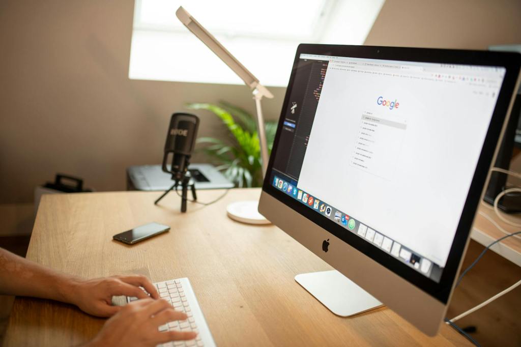 A person using Google on an iMac desktop computer.