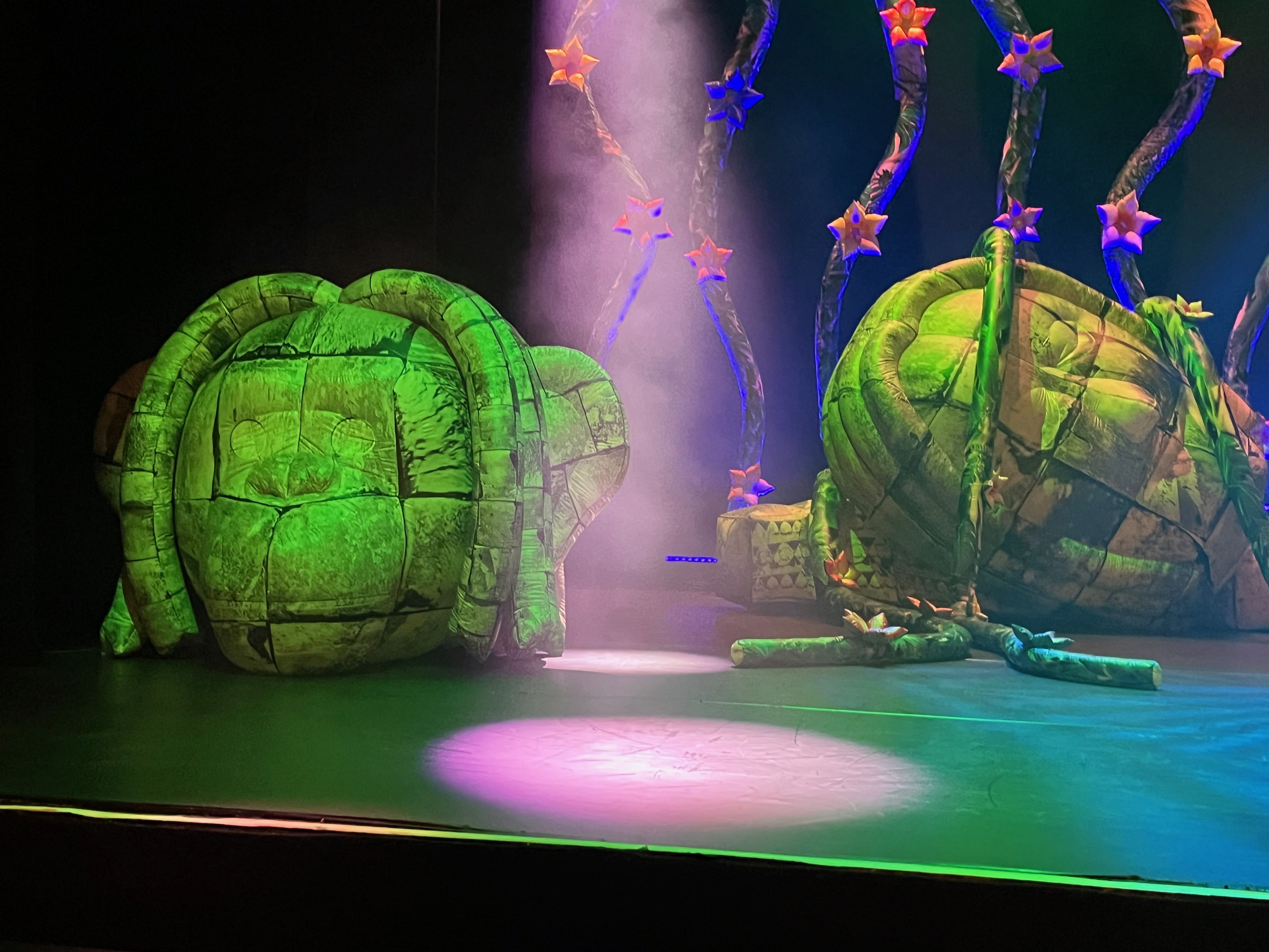 Two inflatable sculptures on the stage for Ross Noble's show Jibber Jabber Jamboree. They are designed to look like rocks carved into strange monkey-like heads.