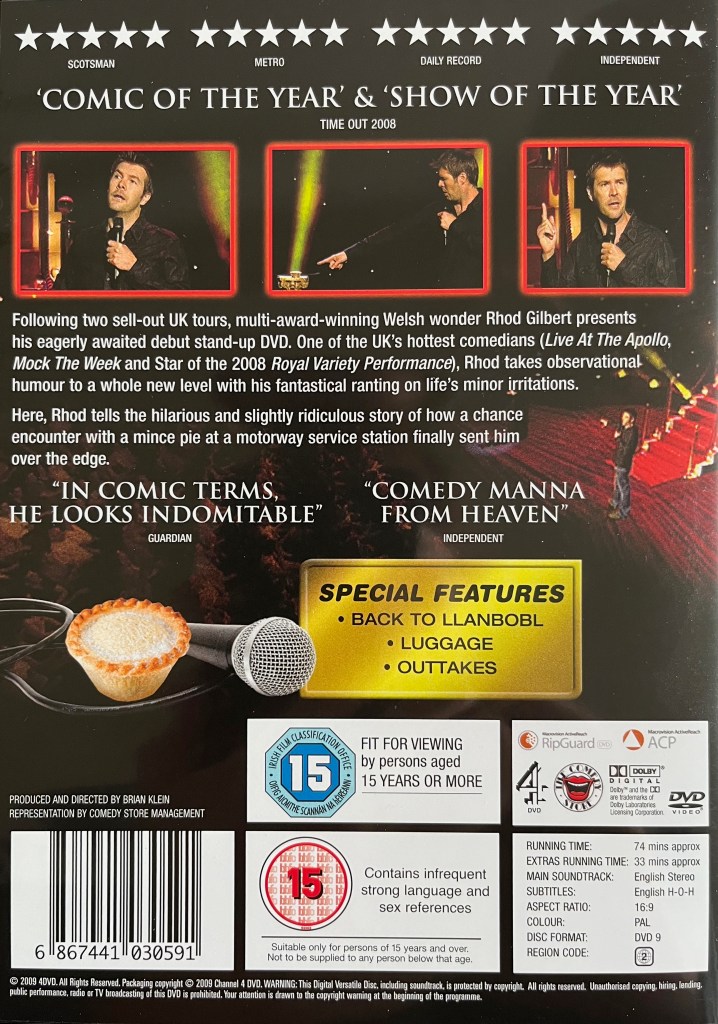 Back cover of the DVD for Rhod Gilbert and The Award-Winning Mince Pie, showing a few photos of Rhod during the show, details about what's on the DVD, and an image of a mince pie with a microphone laid next to it.