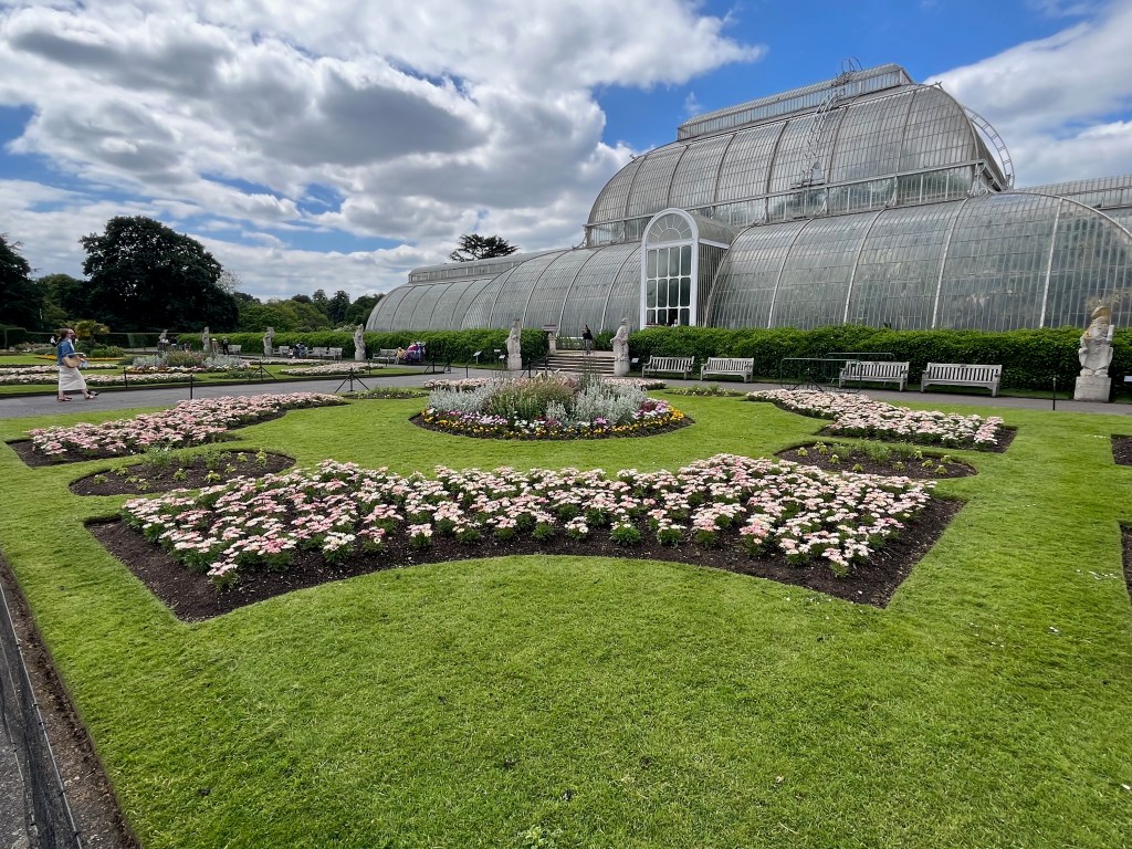 Flowerbeds outside the big glasshouse called Palm House in Kew Gardens, mainly containing white flowers.