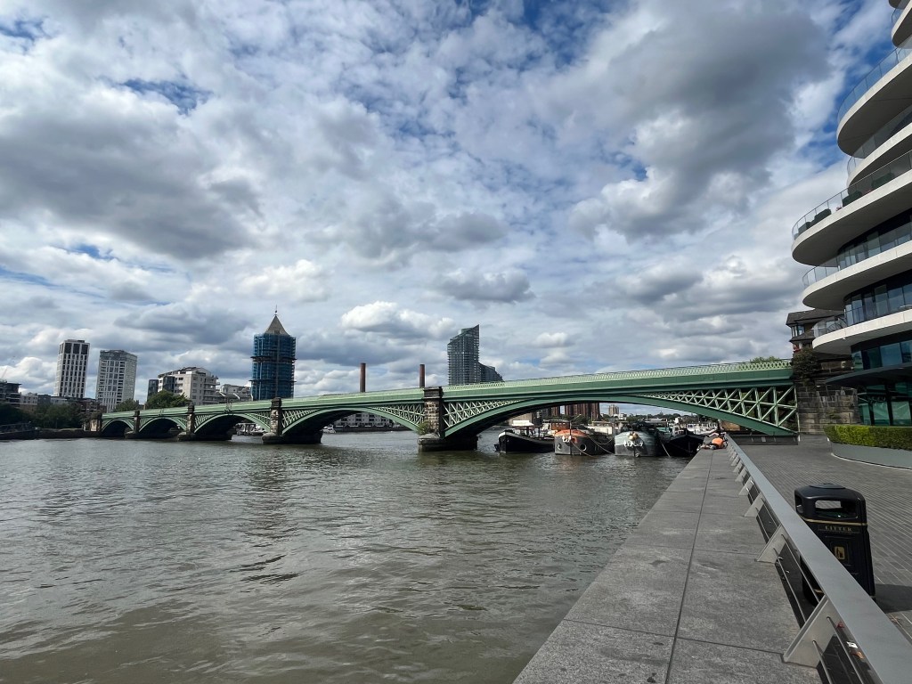 A green painted railway bridge across the River Thames with 5 wide arches.