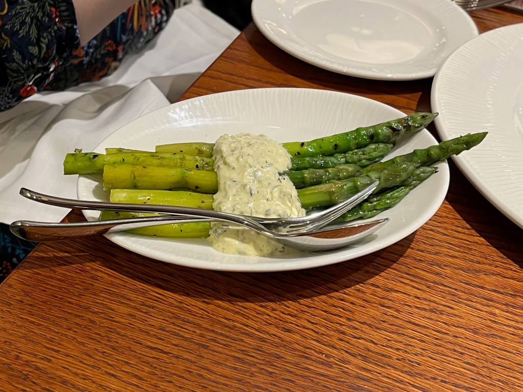 Six long green fingers of asparagus in a white guindilla gribiche sauce at Cardinal Bar and Kitchen.
