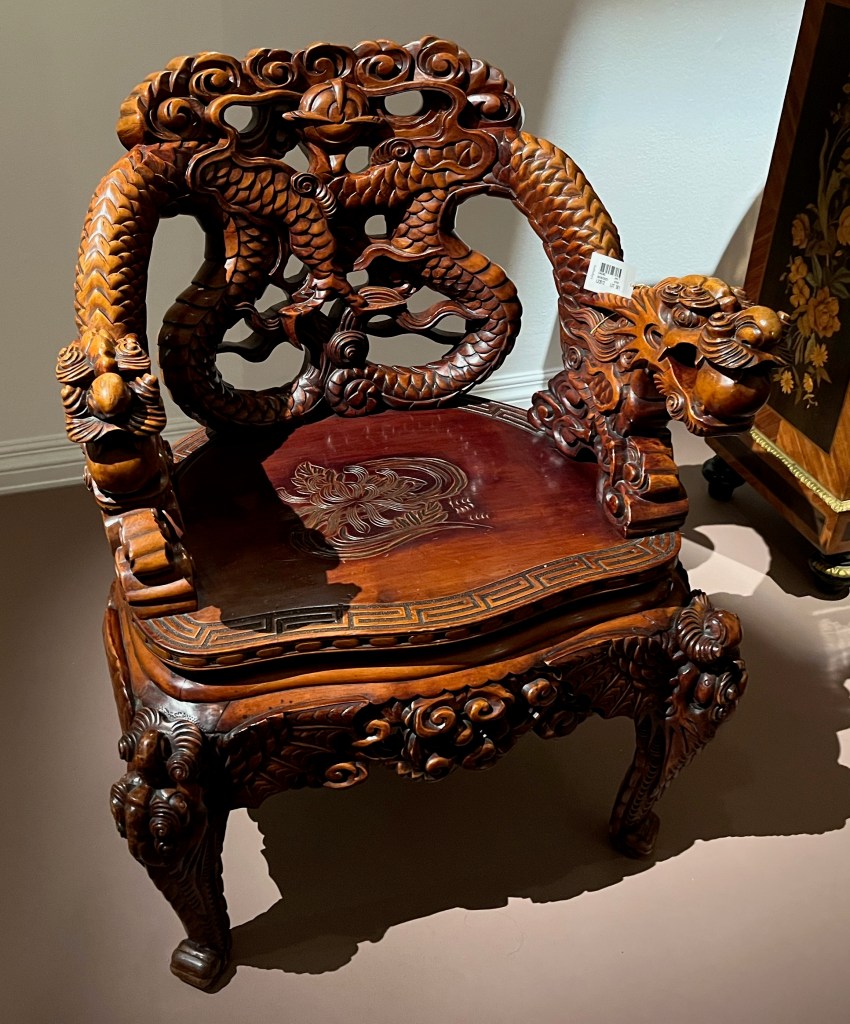 Freddie Mercury's Dragon Throne, a Chinese carved wooden armchair. The back is carved in the form of two dragons, with a solid seat and scroll and dragon-carved legs.