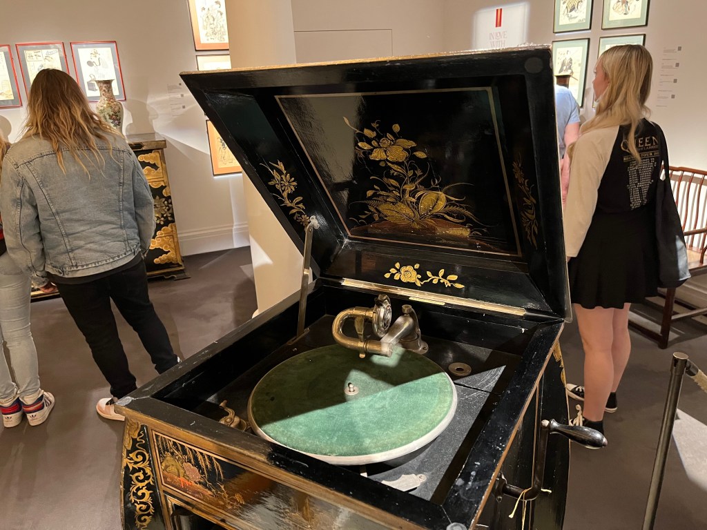Close-up of the record player under the hinged lid of a Japanese decorated gramophone.