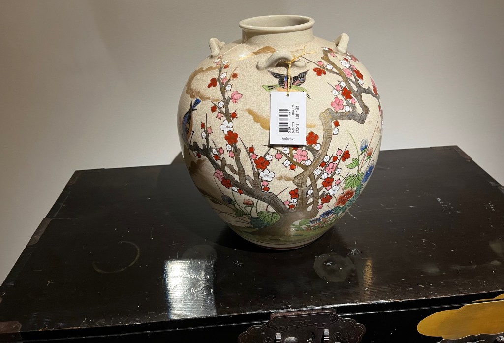 A large, bulbous Japanese vase with a very short neck, decorated in various coloured enamels and gilt, with birds among plum blossom, flowers and grasses.