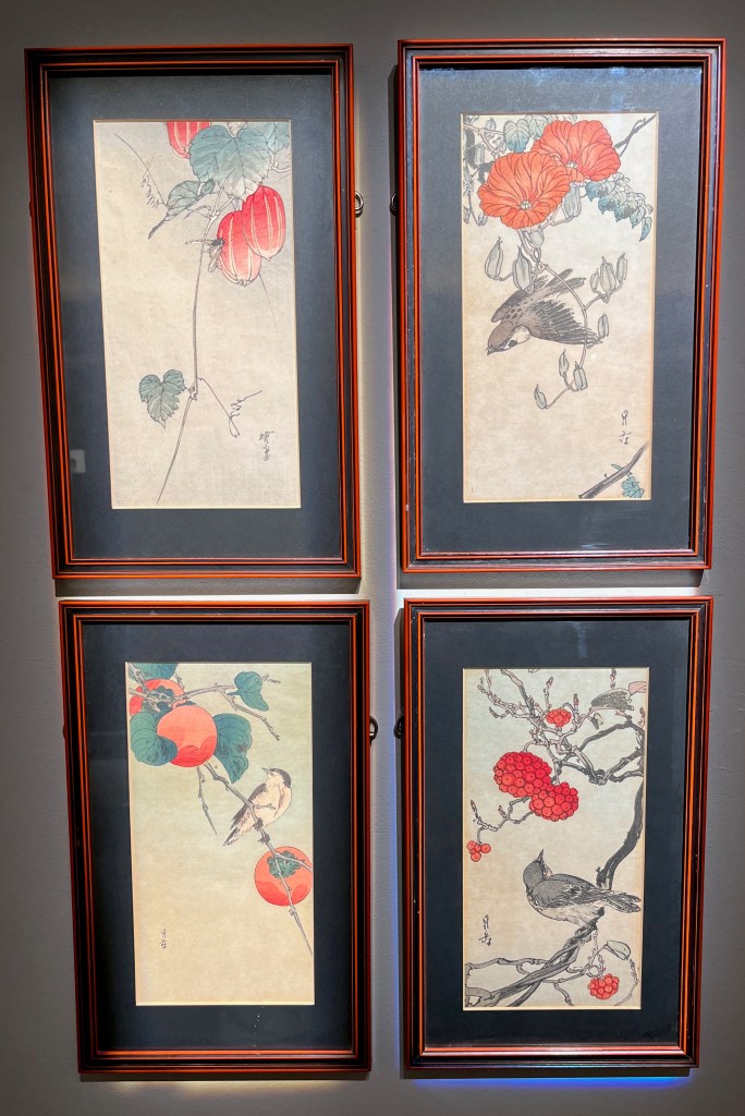 Four Japanese woodblock prints depicting birds perched on branches and stems amongst flowers and foliage.