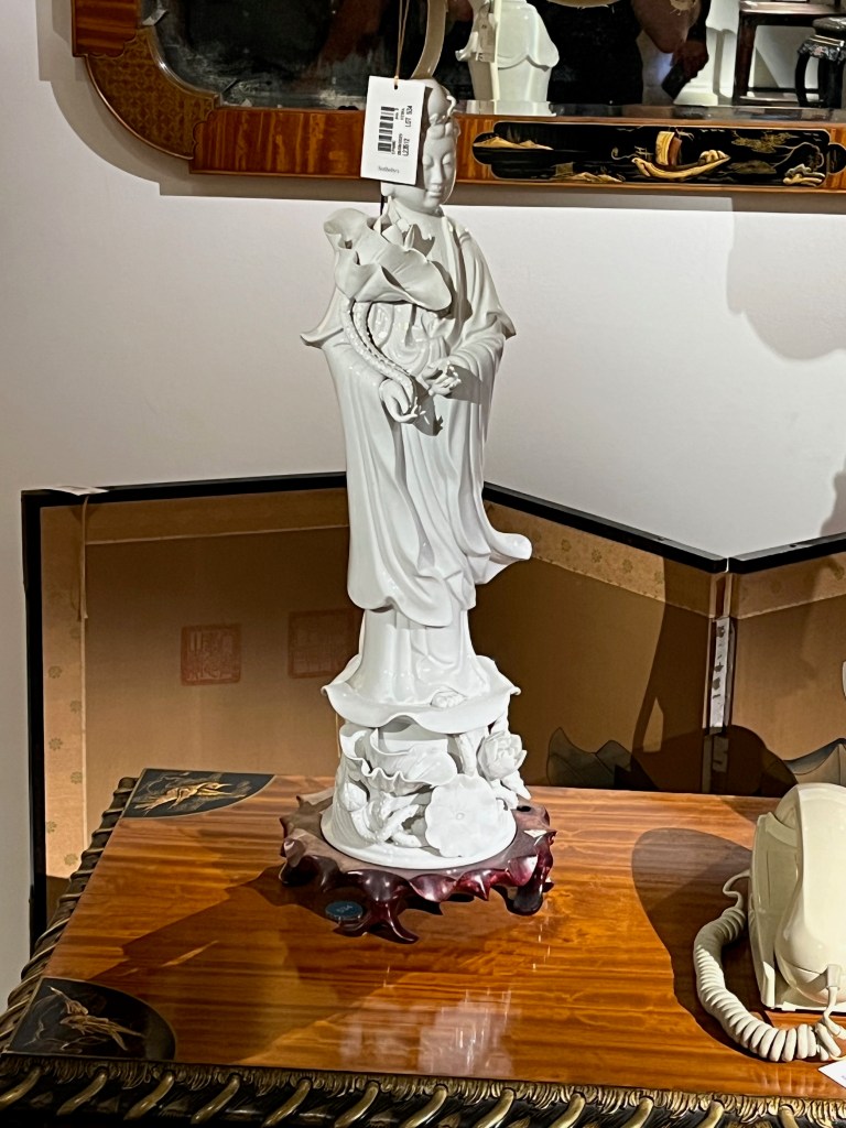 A white statue of a figure in a long flowing robe.