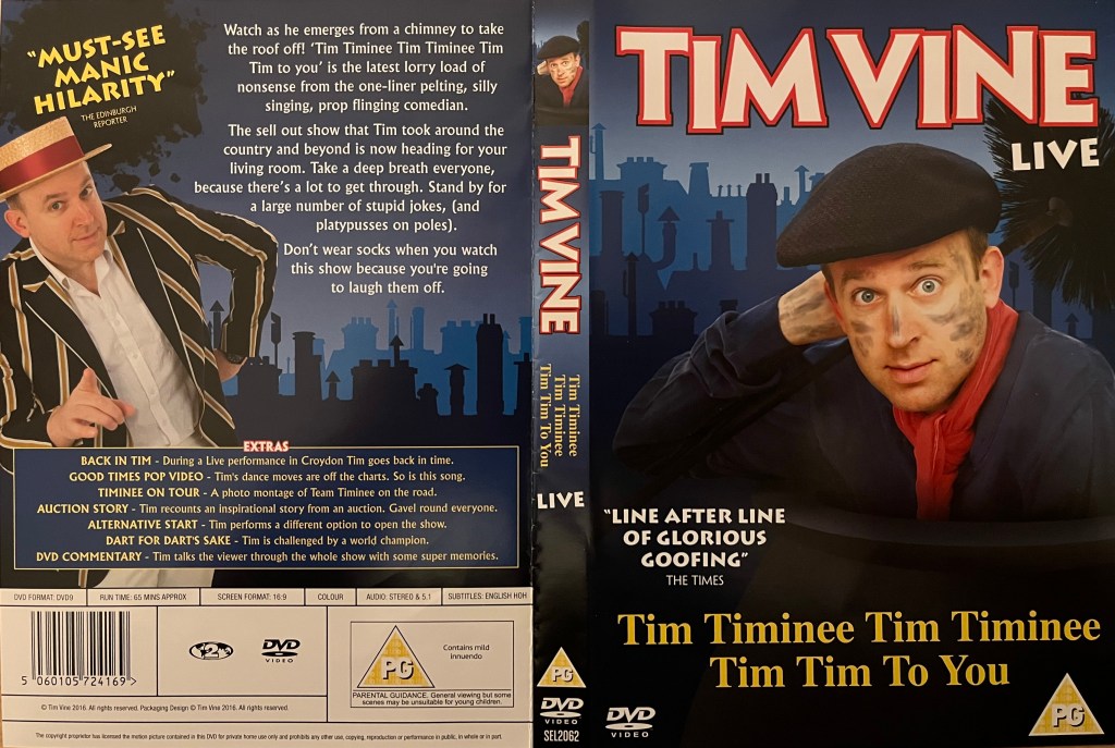 DVD cover spread for Tim Vine, Tim Timinee, Tim Timinee, Tim Tim To You. The front shows him wearing a flat cap with soot marks streaked across his face, in front of a backdrop of roofs and chimneys. The back cover, with the same backdrop, shows him wearing a straw boater hat and a black jacket with white stripes over a white shirt.
