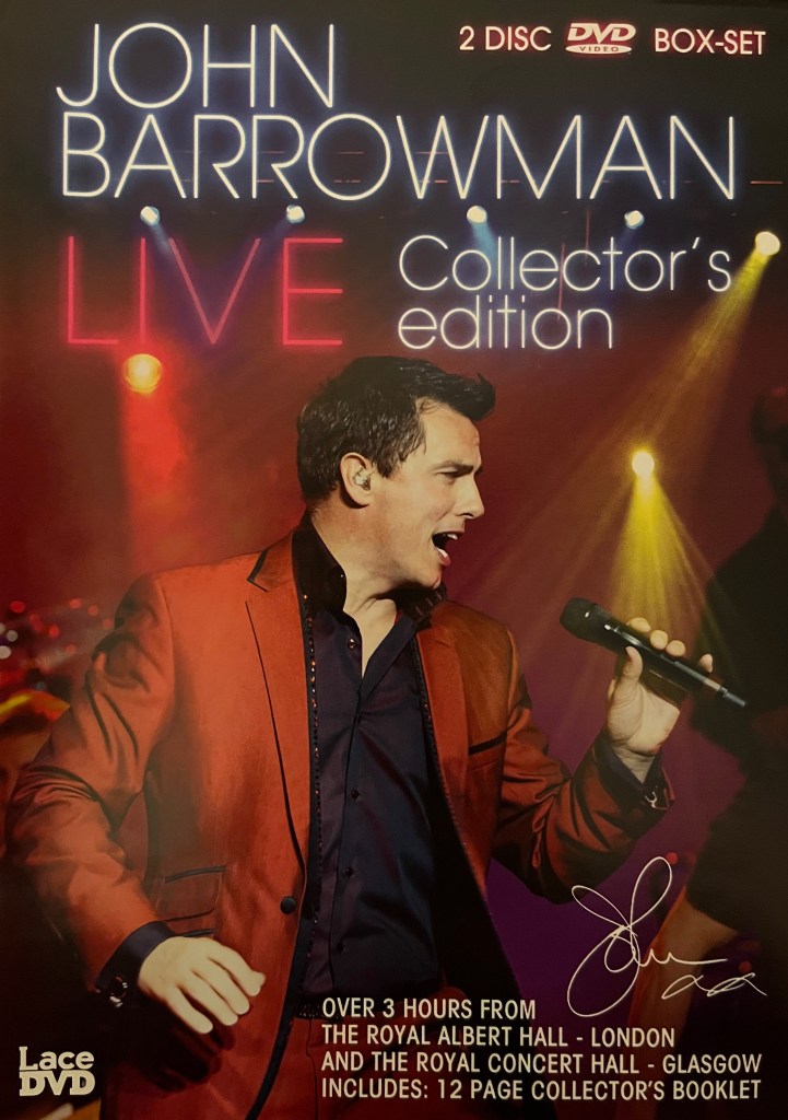 Front cover of the John Barrowman Collector's Edition DVD set, showing him singing while wearing a red jacket over a black shirt.