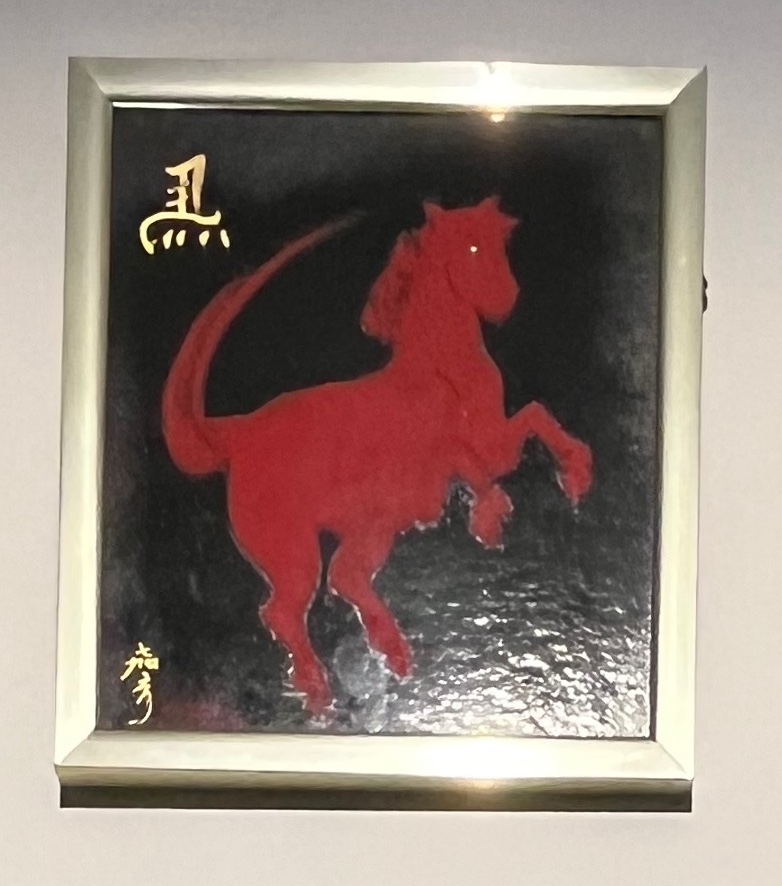 A painting of red horse silhouette against a black background.