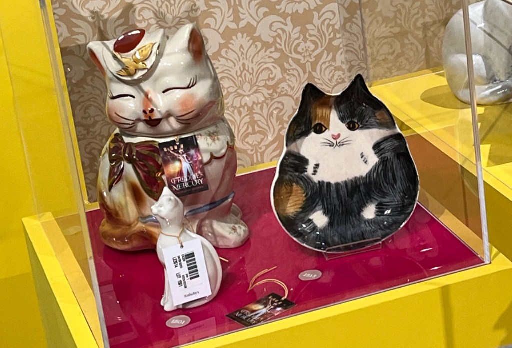 A cookie jar and pottery dish, both designed to look like cats, as well as a small white glazed figurine of a cat.