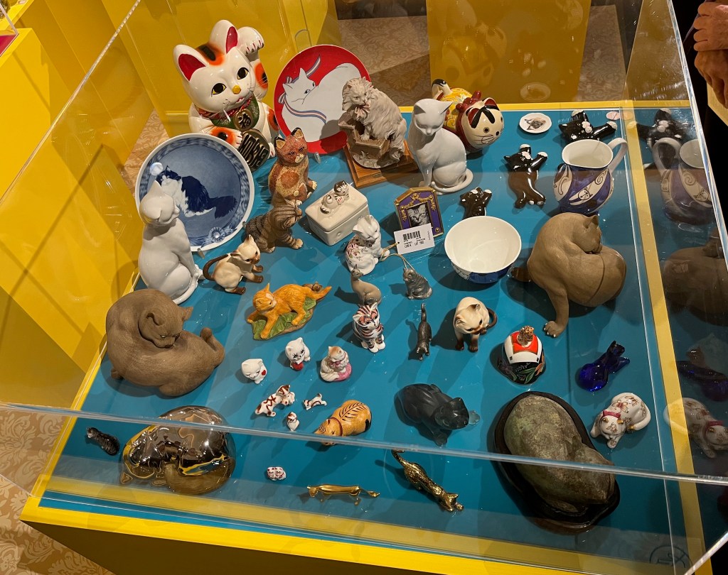 A large and colourful collection of ornaments of cats, in a variety of sizes and designs.