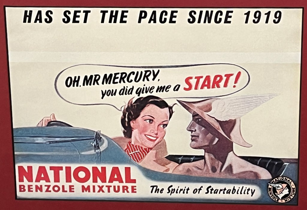 An advert for National Benzole mixture. White text at the top says it has set the pace since 1919. Below this, a smiling lady sitting at the steering wheel of a car is saying to a man next to her Oh, Mr Mercury, you did give me a start! Text at the bottom then says National Benzole Mixture, the spirit of startability.