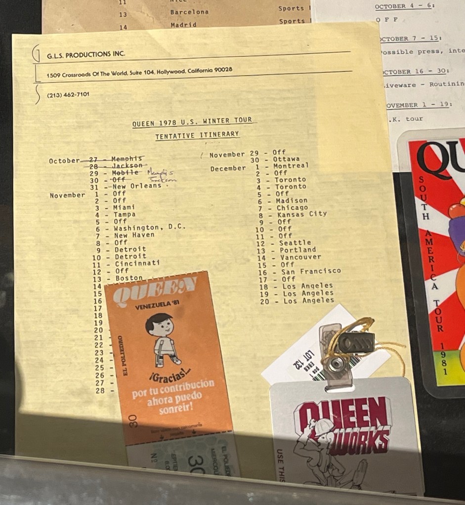 A tentative itinerary for Queen's tour of the USA in October to December 1978, with a list of dates and cities, including days off in between. There's also a backstage pass for a Venezuela show during the band's Hot Space tour in 1981, with a cartoon image of a young boy on it.