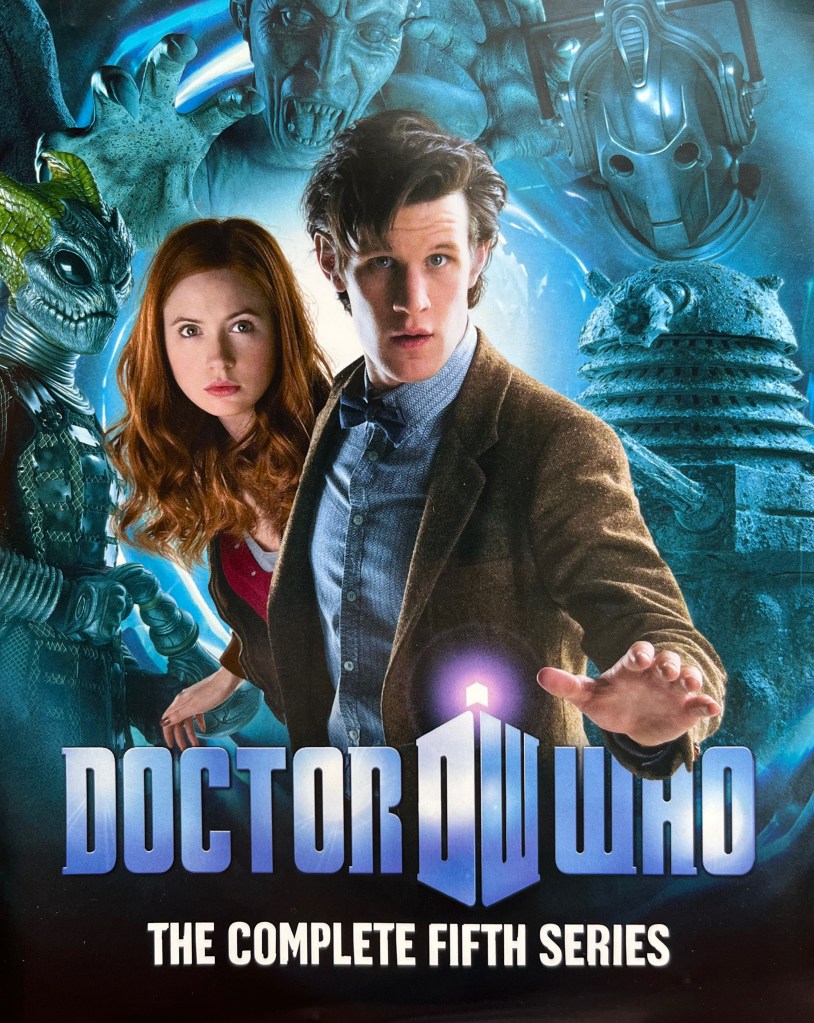 Front cover of the original Blu-ray release for Doctor Who Series 5. It shows Matt Smith as the Doctor and Karen Gillan as red-headed companion Amy Pond, looking a bit alarmed, while surrounded by images of a Silurian, a Weeping Angel, a Cyberman and a Dalek.