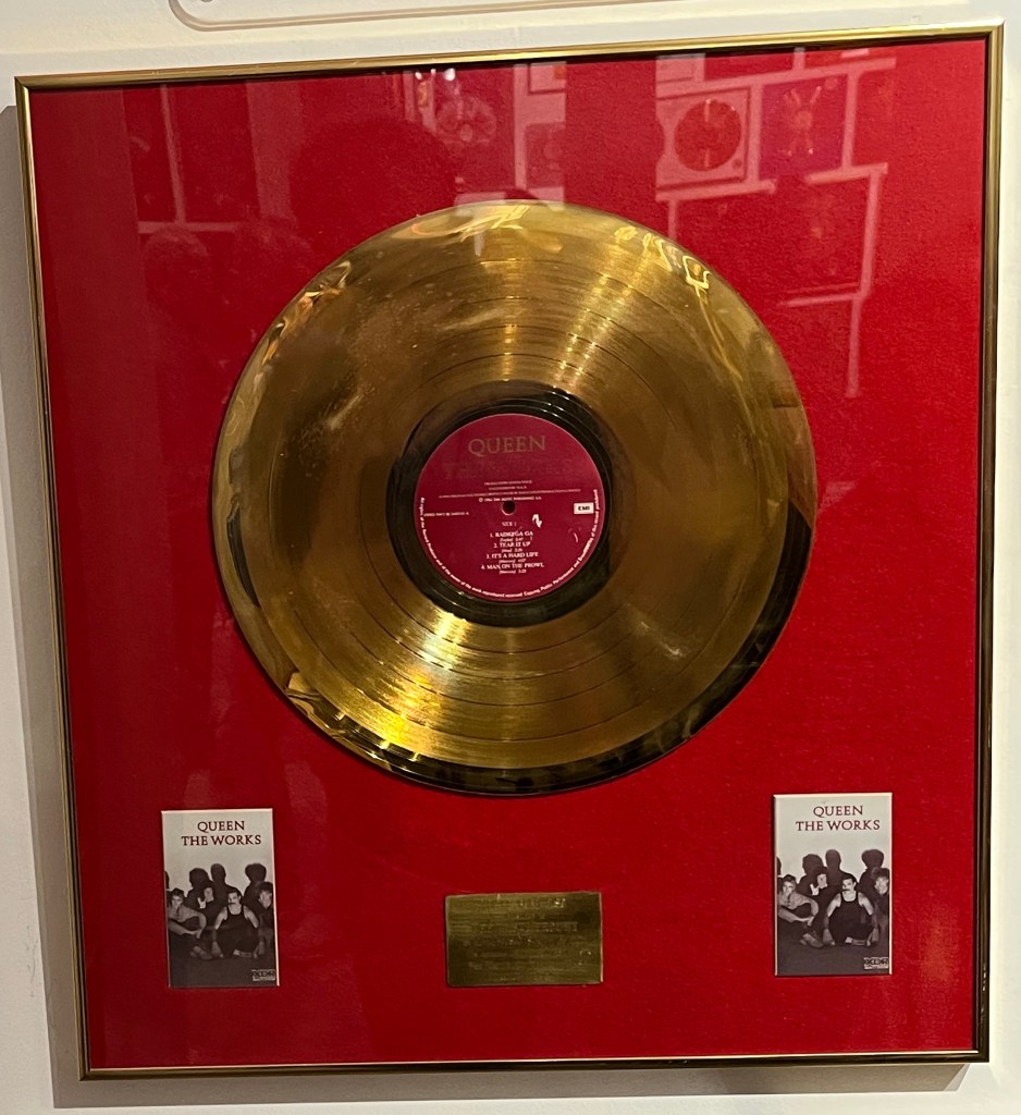 Disc sales award for The Works, with a large gold disc against a red background.