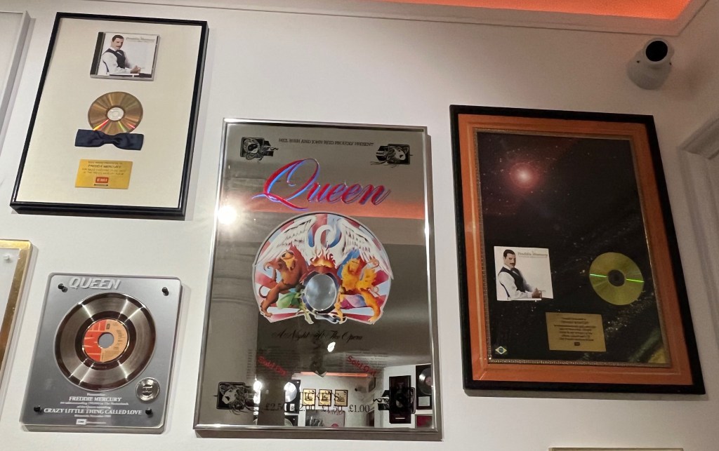 2 sales awards for The Freddie Mercury Album, one of which has a bow tie attached to the bottom of the disc in the case, plus a Dutch sales award for Crazy Little Thing Called Love, and a commemorative mirror in the style of a concert poster for A Night At The Opera.