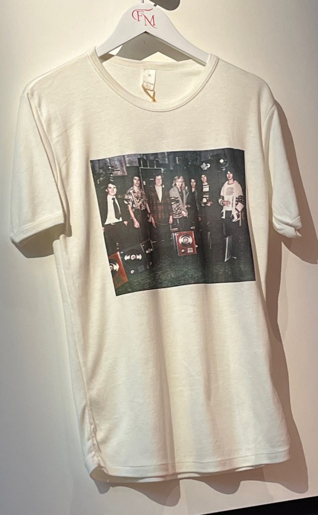 A white cotton T-shirt printed with a colour photograph of Freddie Mercury, Queen and their manager John Reid with their BPI presentation awards for the album A Day At The Races.