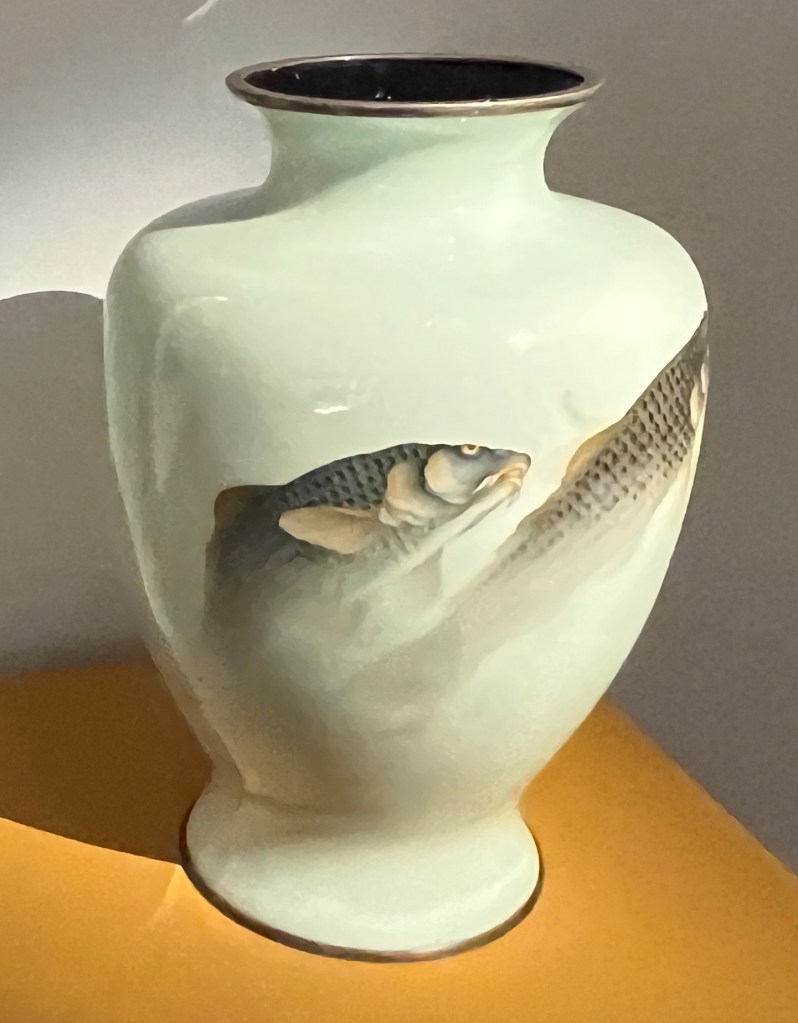 A large white enamel vase, featuring a couple of carp swimming together on the outside.