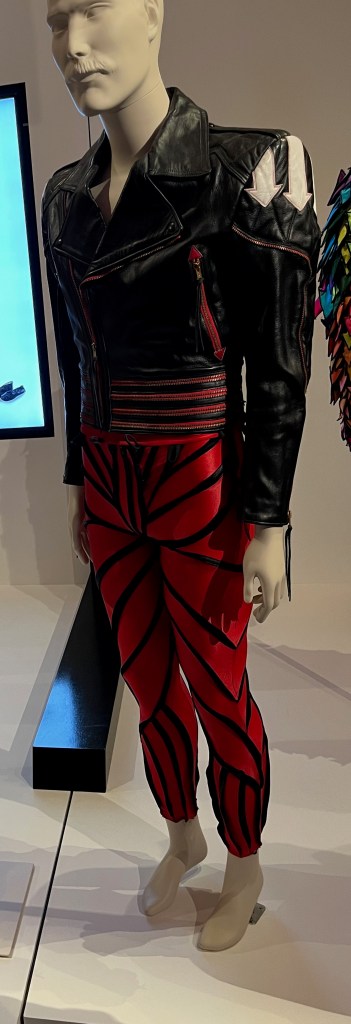 A black leather jacket with red accents and white arrows, with scarlet zip detail to the cuffs, sleeves and front panels, and in four horizontal bands outlining the waist. The jacket is embellished at each shoulder with three white leather arrows with red stitching.