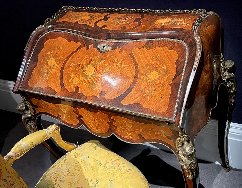 An ornately decorated bureau in rosewood, kingwood and fruitwood.