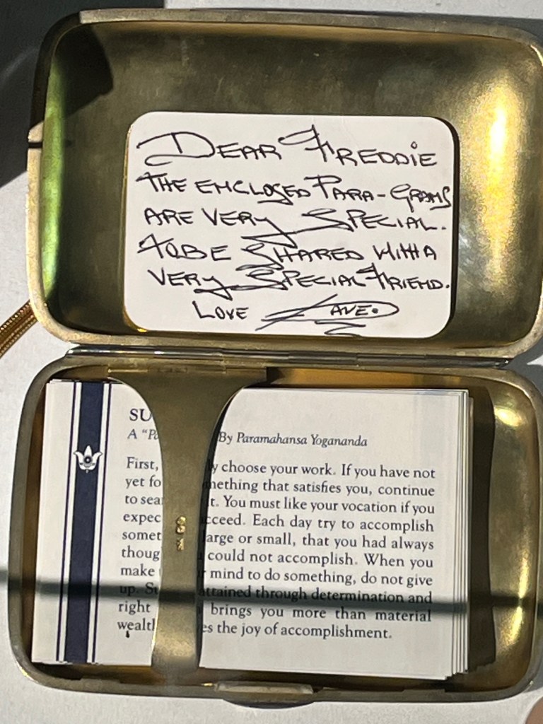 A silver cigar case containing a set of typed spiritual advice cards. It also has a handwritten note from Dave Clark that says Dear Freddie, the enclosed Para-grams are very special. To be shared with a very special friend. Love Dave.