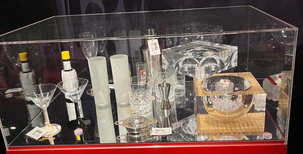 A selection of drinking glasses, bottles and a cube-shaped ice bucket.