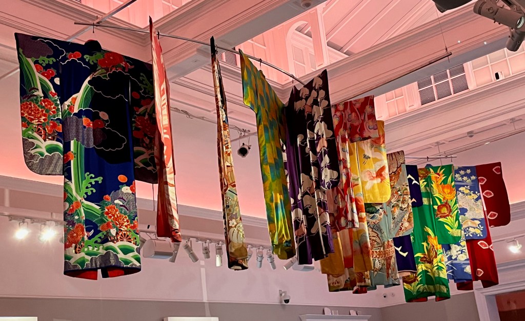 A selection of colourful kimonos on a metal rack hung from the ceiling.