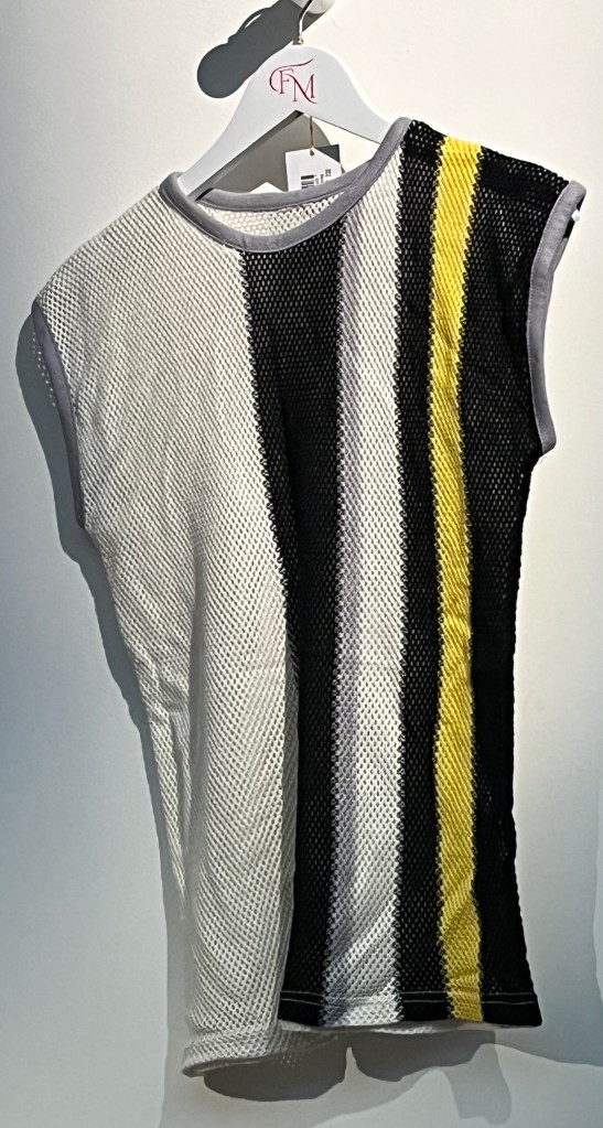 A white mesh sleeveless top with black, grey and yellow vertical stripes to left-hand side.