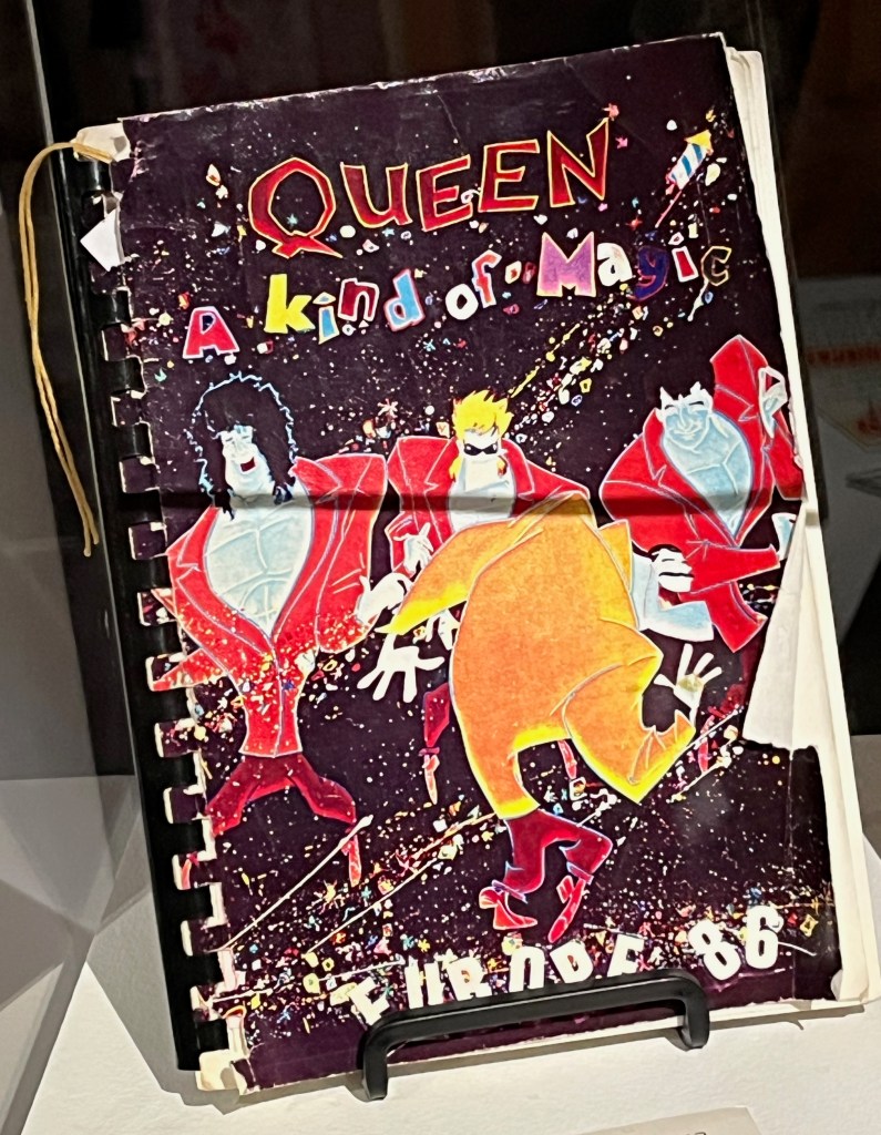 The cover of a planner for Queen's Magic tour, showing colourful, stylised, cartoon versions of the band members, with colourful text saying Queen, A Kind Of Magic, at the top, and Europe '86 at the bottom.