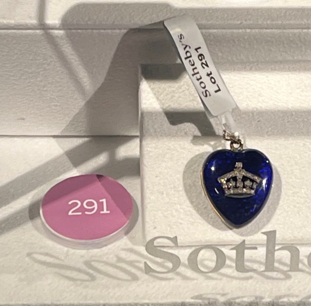 A deep blue enamel heart-shaped pendant, set with rose-cut diamonds in the shape of a crown.