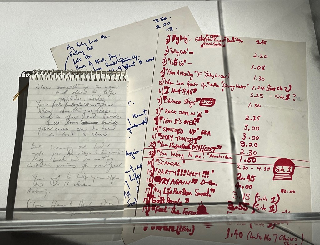 Freddie Mercury's notes for the album The Miracle. They include a sheet of draft lyrics that includes the lines When something so near and dear to life explodes, inside, you feel your soul is set on fire. But screaming out loud gets you nowhere in this world. There are also 2 sheets of paper with draft track listings for The Miracle album, with song titles including My Baby Does Me, Falling Out, Let's Go, Have A Nice Day, When Love Breaks Up, I Want It All, Chinese Strings, Rock Jam In A, Now It's Over, Speeded Up, Stay Tonight, You Hijacked My Heart, You Belong To Me, Scandal, Party Party, Try Again, My Life Has Been Saved, God's People and Feel The Force.