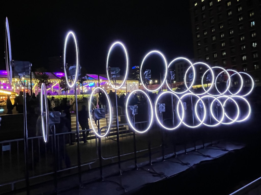 Two rows of large rings, each lit up in white, that look like they're suspended in mid-air.