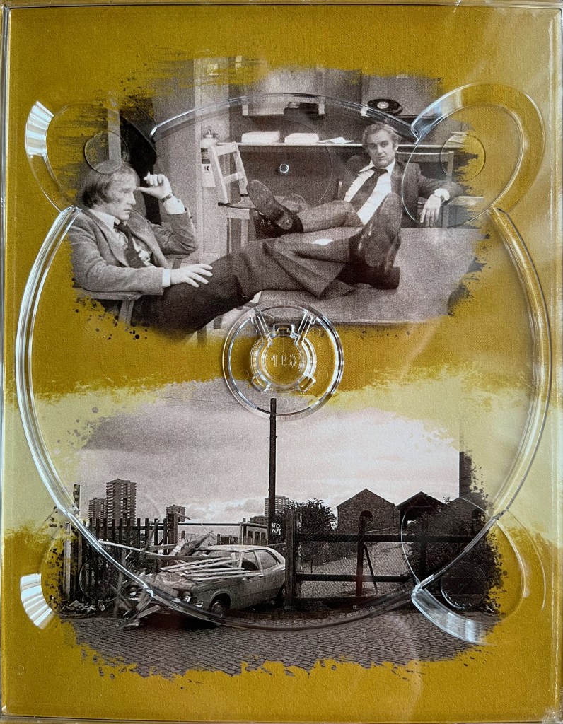 2 black and white photos. The top photo shows Regan and Carter sat down on adjacent sides of a table, with their feet resting up on the table. The bottom photo shows a car smashing through a gate. The images are placed on a gold background, and are from one of the panels in the Blu-ray box set for The Sweeney Series 4.