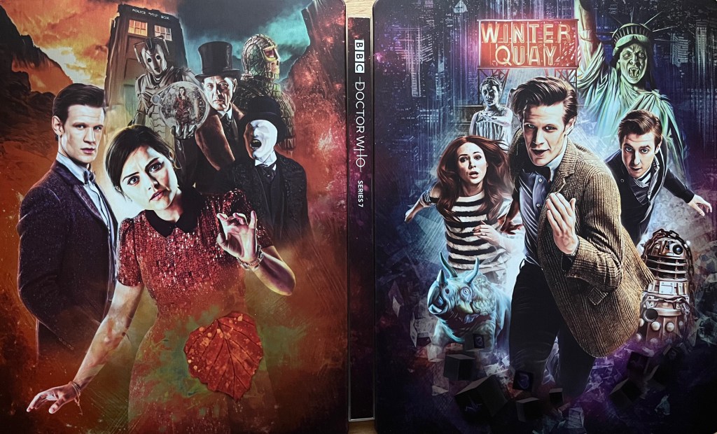 The cover spread artwork for the Doctor Who Series 7 Blu-ray steelbook. The front cover, on the right, shows Matt Smith's Doctor with Amy and Rory running towards us, with a Dalek and 2 Weeping Angels behind them, and a neon sign above them saying Winter Quay. The back cover on the left then shows the Doctor again, standing next to Clara this time, while behind them are the Tardis and various characters including The Great Intelligence and a Cyberman.