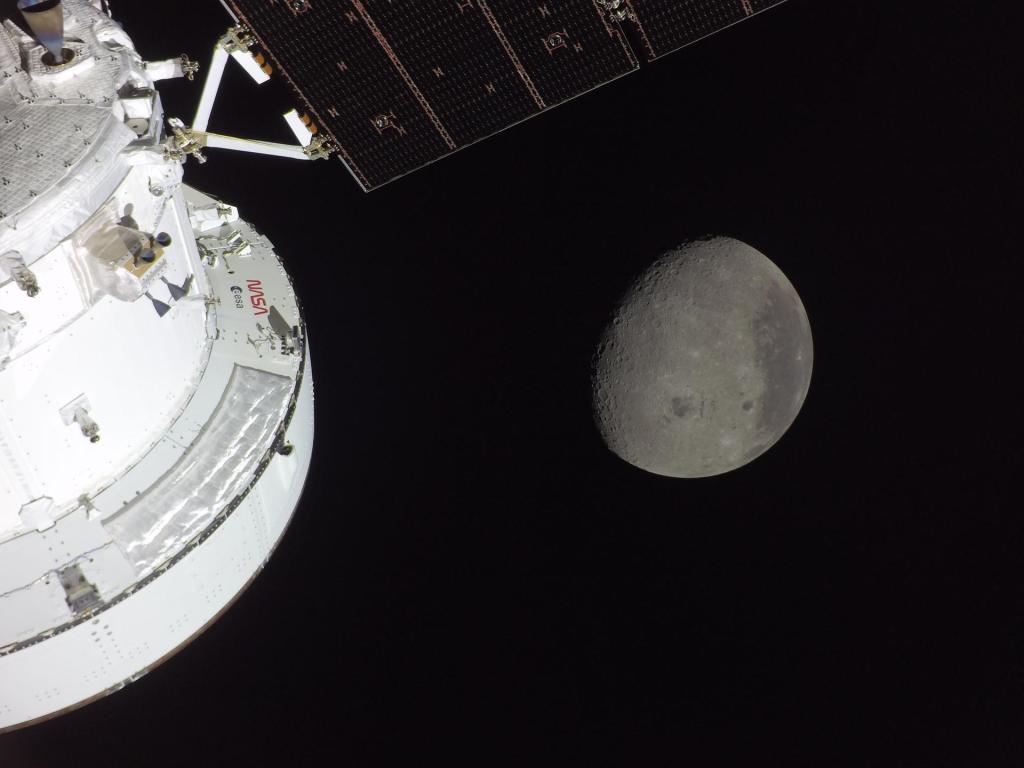A view from a camera attached to the Orion spacecraft, with part of the ship visible on the left, as it approaches the moon.