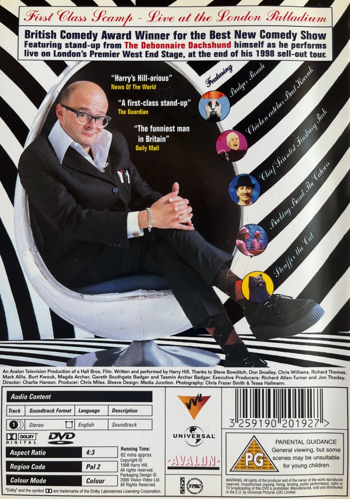 Back cover for Harry Hill's First Class Scamp DVD, showing him sat in a chair, his legs crossed at the knees and his hands clasped together over the top of them. Other characters from the show are displayed in small circles next to their names. The background and the floor is decorated with black and white stripes.