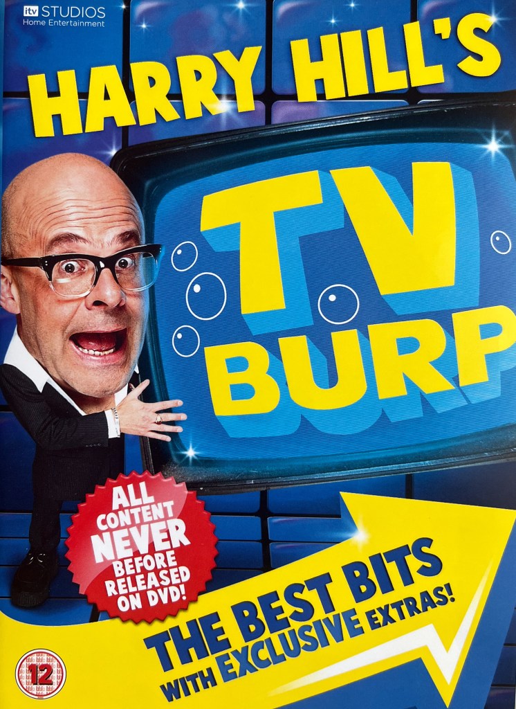 Front cover of the DVD for Harry Hill's TV Burp - The Best Bits. Below the words Harry Hill's in large yellow letters is a version of Harry with a large head on a small body holding a big TV with the words TV Burp on the screen in the same font style. The words The Best Bits With Exclusive Extras are in bold blue letters at the bottom of the cover, in a yellow arrow pointing to the right.